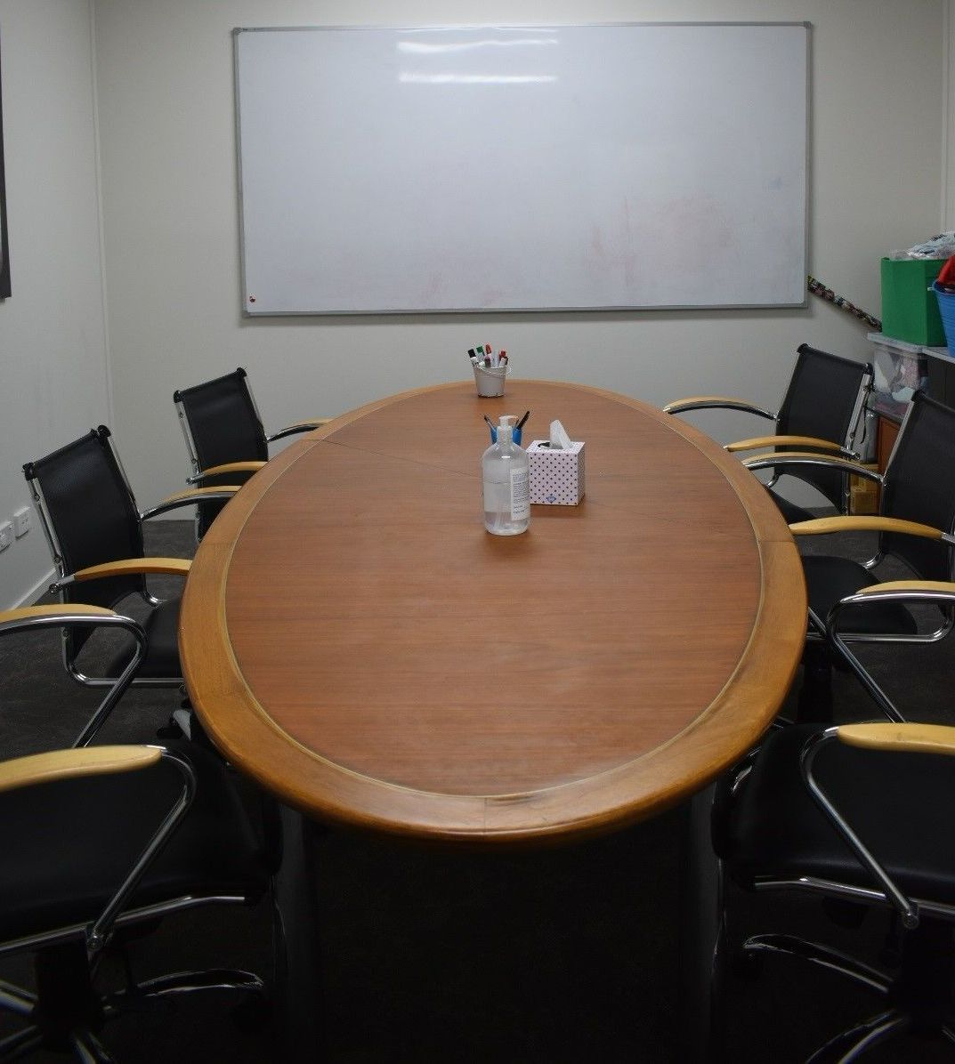 A conference room with a large wooden table and chairs