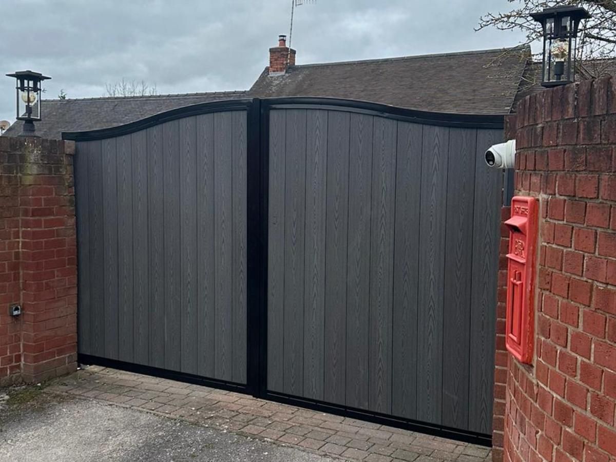 Hinged grey arched composite driveway gates in Bradford