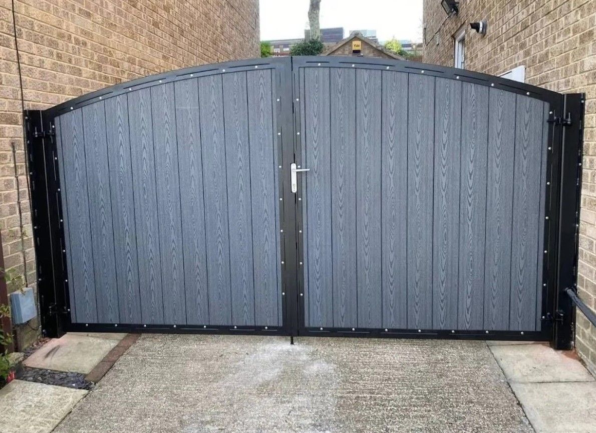 Hinged grey arched composite driveway gates in Portslade
