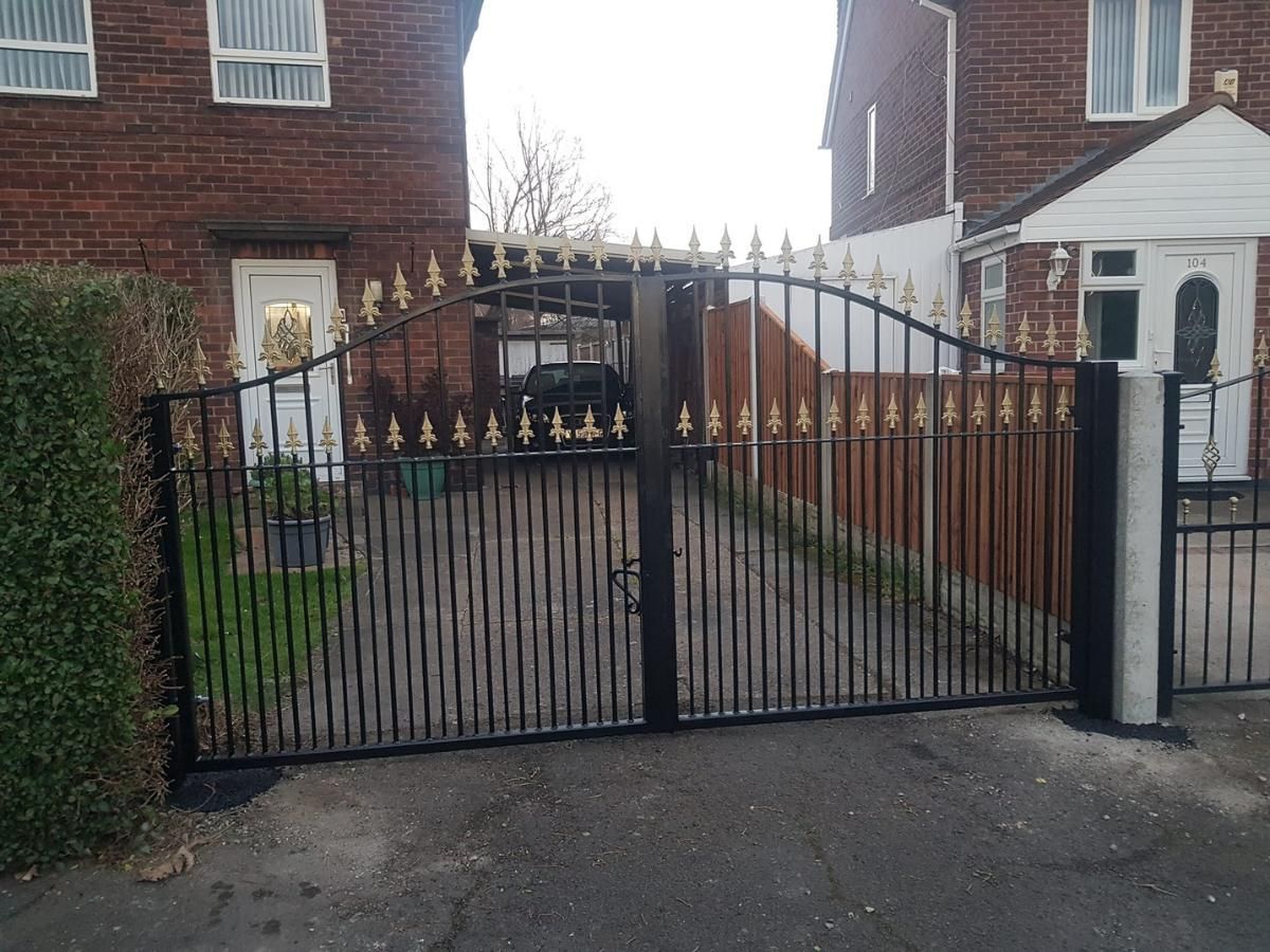 Composite Gates UK arched metal driveway gates with gold fleur de lis tops