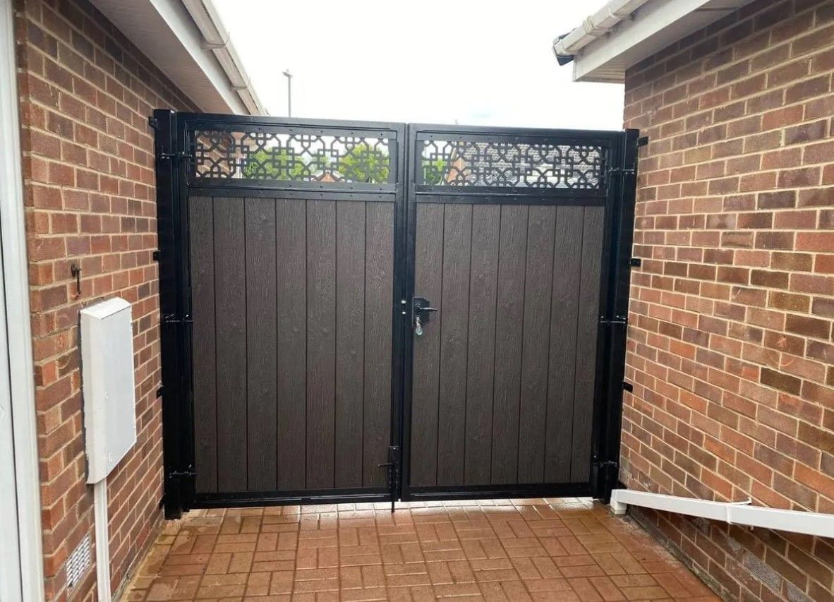 Chocolate composite driveway gates with trellis topper installed in 
Gloucester