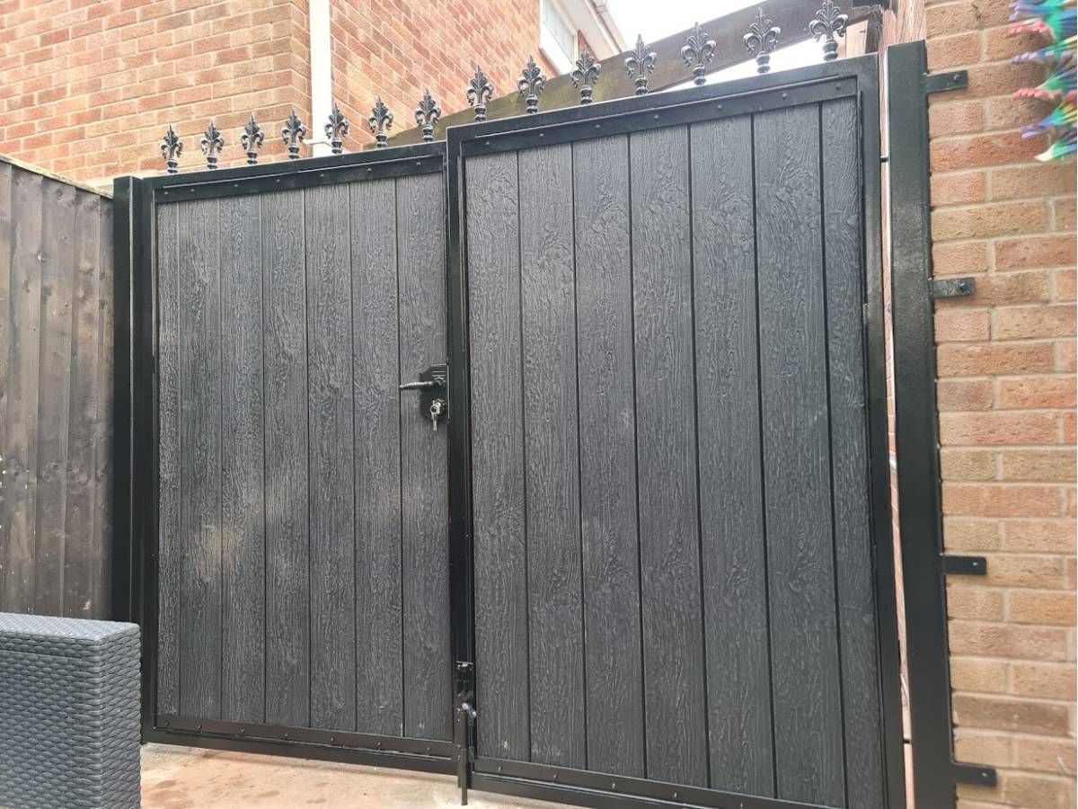 Double 6 foot grey composite driveway gates with fleur de lis top