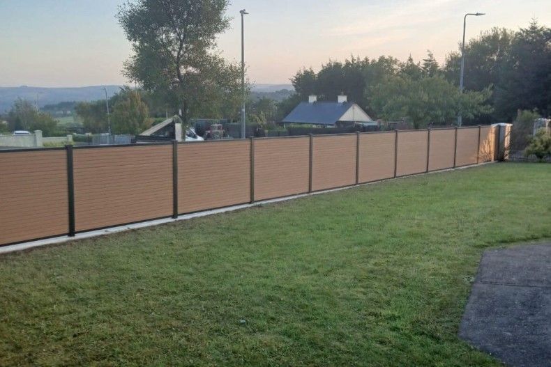 Composite Gates UK light grey composite fencing installed on a brick wall between brick pillars in Derby