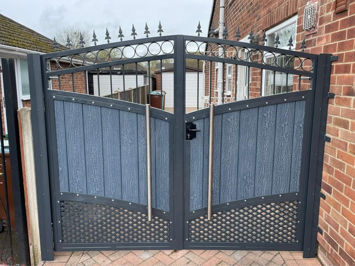 Arched silver grey composite gates with metalworks above and below with additional stainless steel handles 