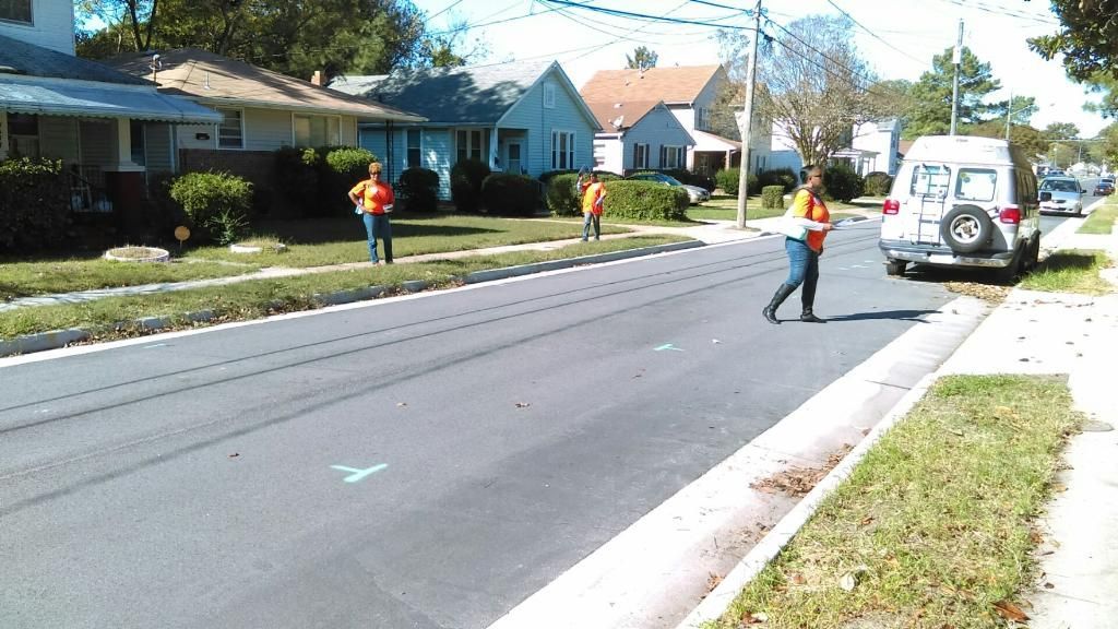 A white van is parked on the side of the road as Get Out The Vote volunteers canvass