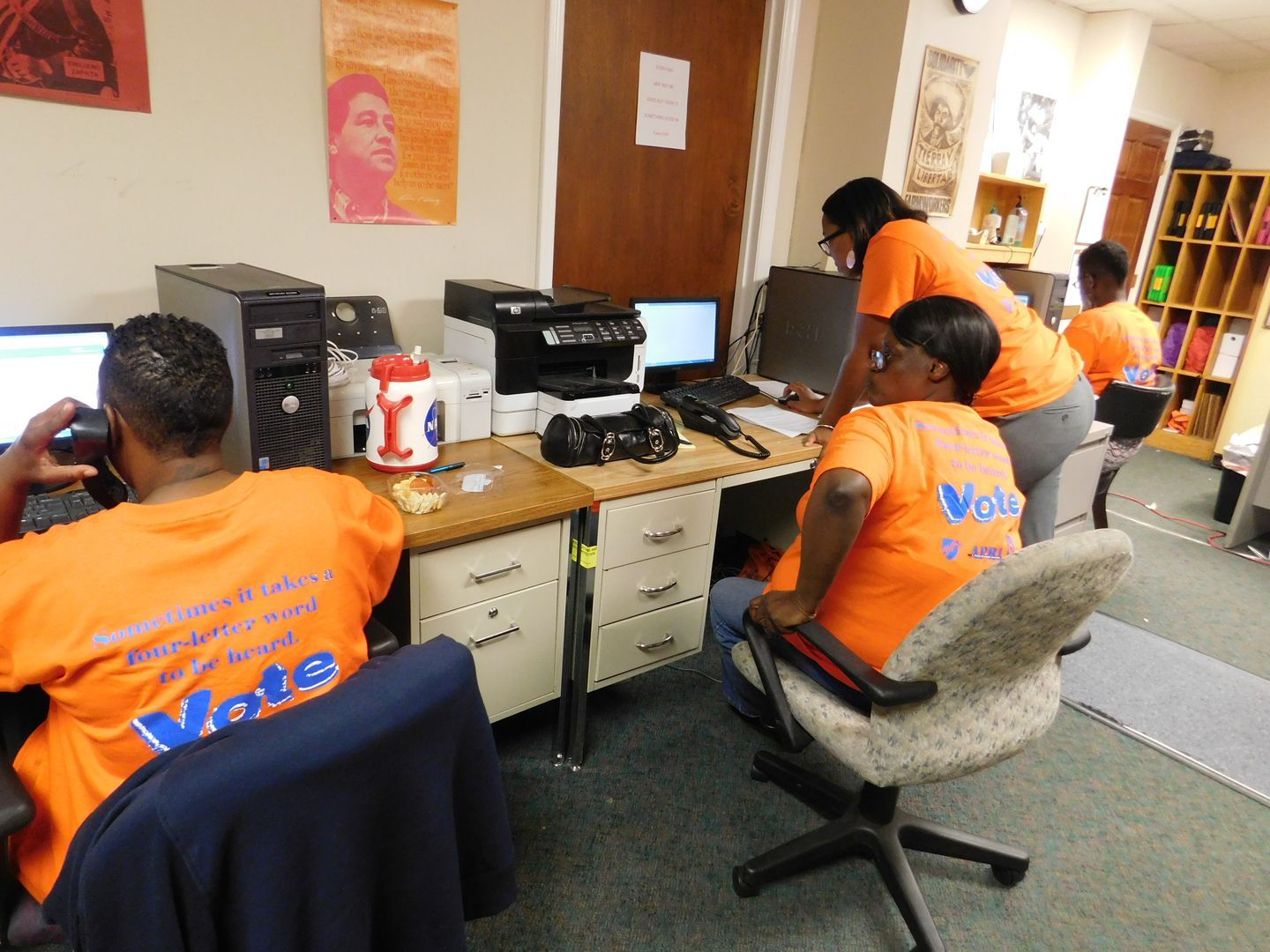 A group of Get Out The Vote volunteers  wearing orange shirts that say 