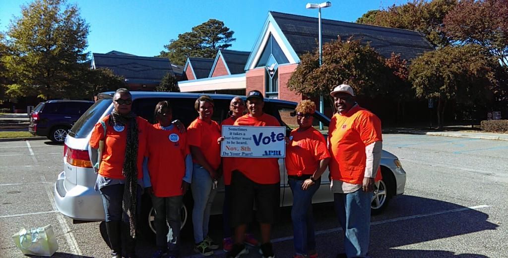 A group of Get Out The Vote volunteers  holding a sign that says vote