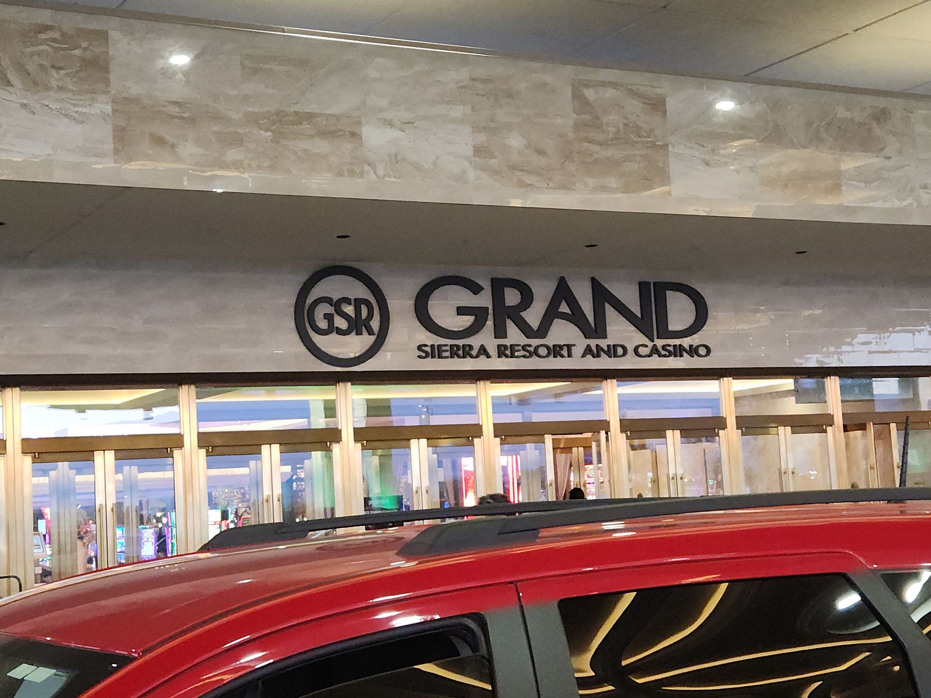 A red suv is parked in front of the grand sierra resort and casino