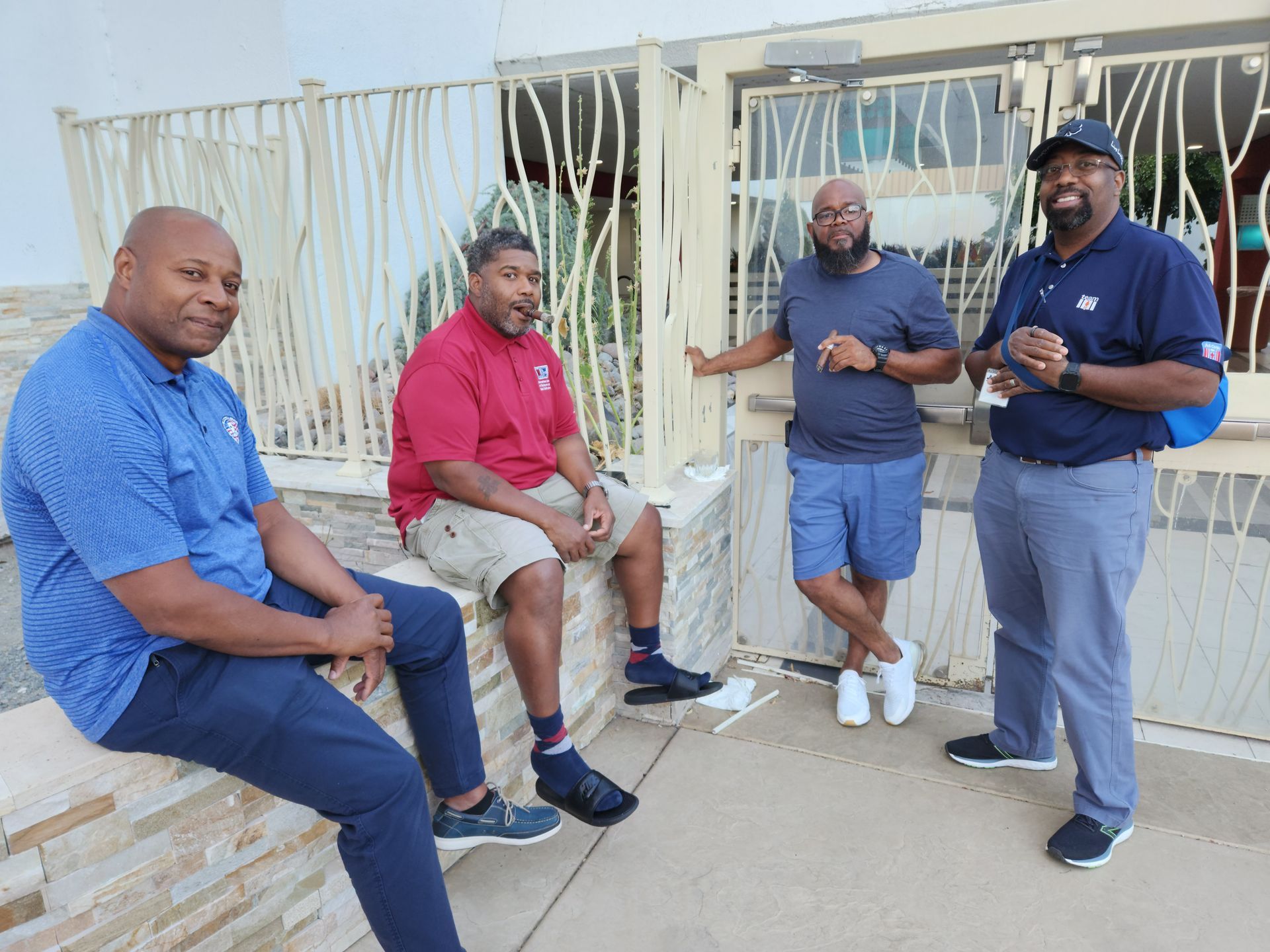 A group of men are sitting on a stone wall  at the APRI 