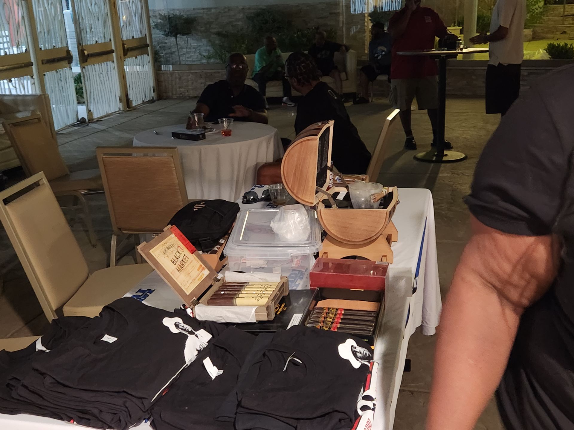 A man is standing in front of a table with cigars on it