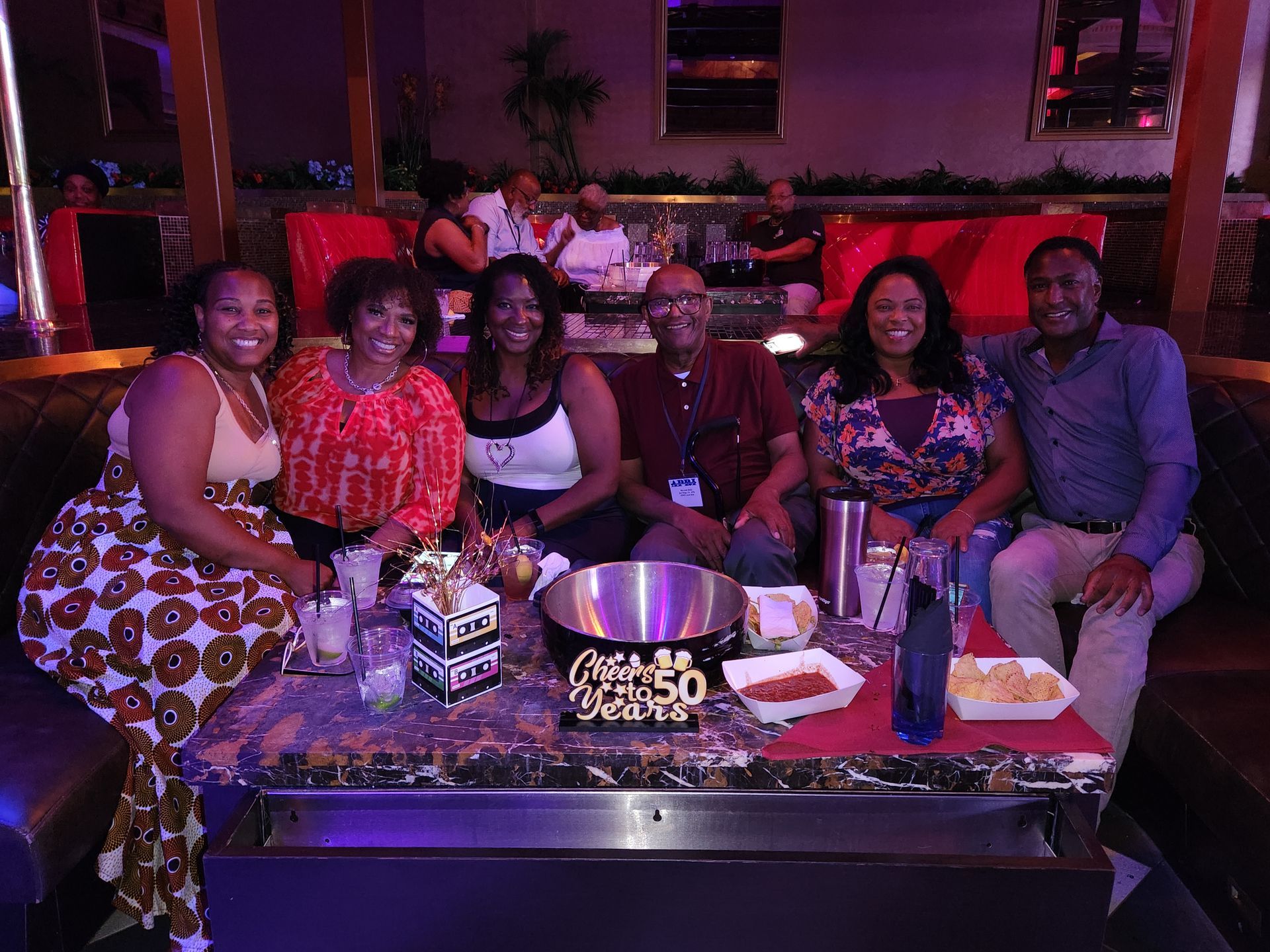 A group of people are sitting around a table at an APRI 