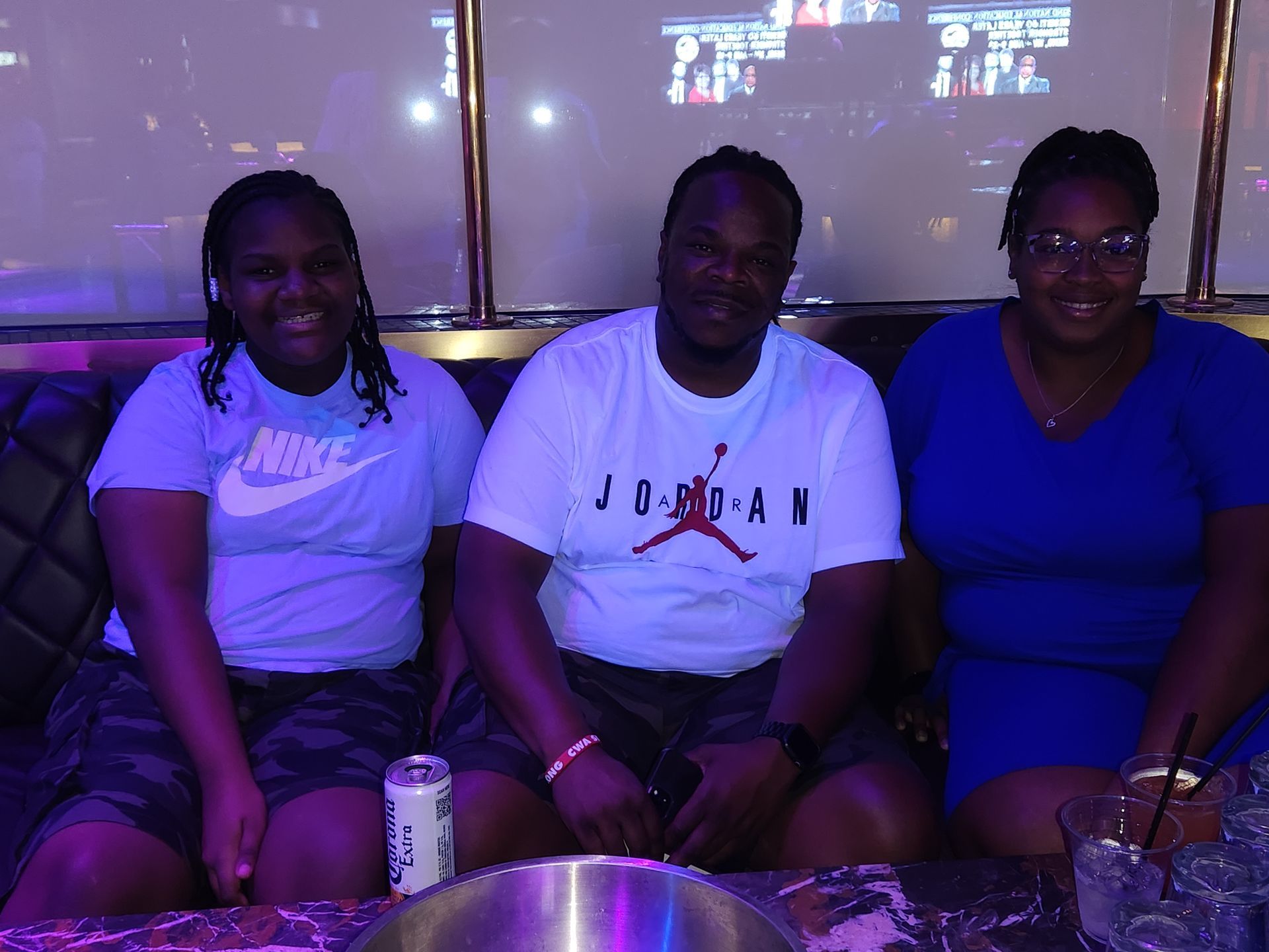 A man wearing a jordan shirt sits next to two women