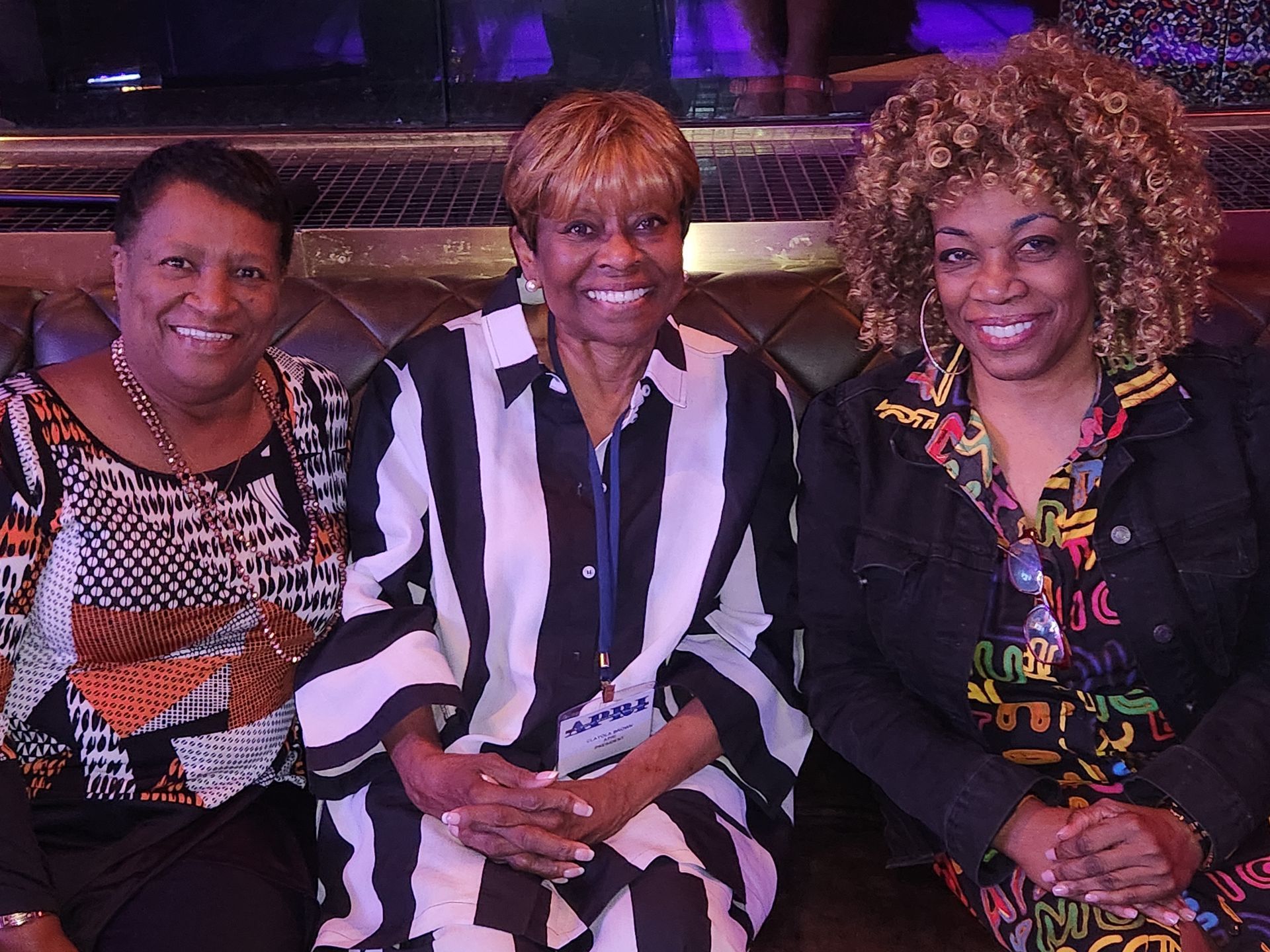 Close up of two women sitting on a couch with APRI President Clayola Brown in the center