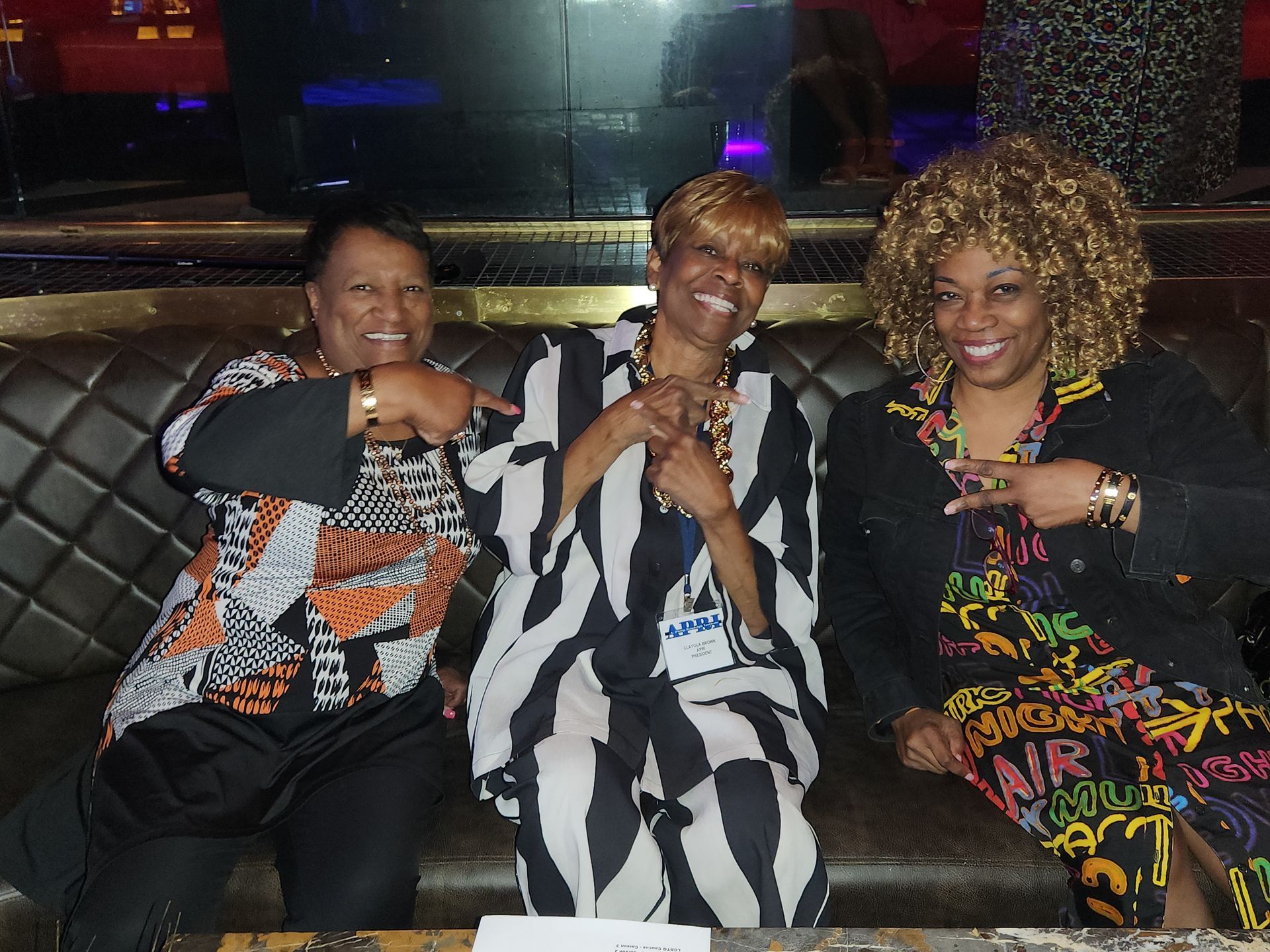 Two women sitting on a couch with APRI President Clayola Brown in the center