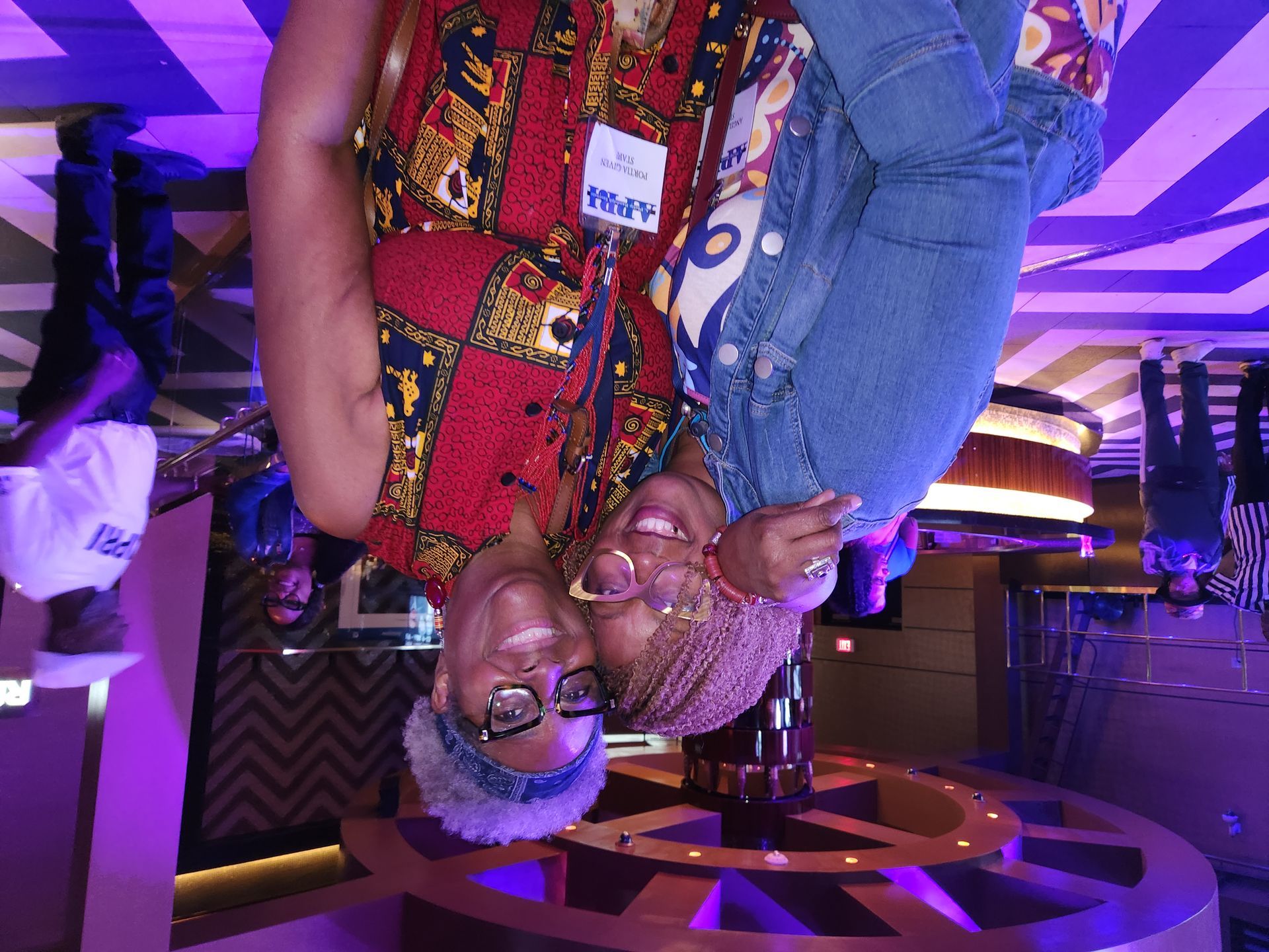Two women in a room with purple lights at an APRI 