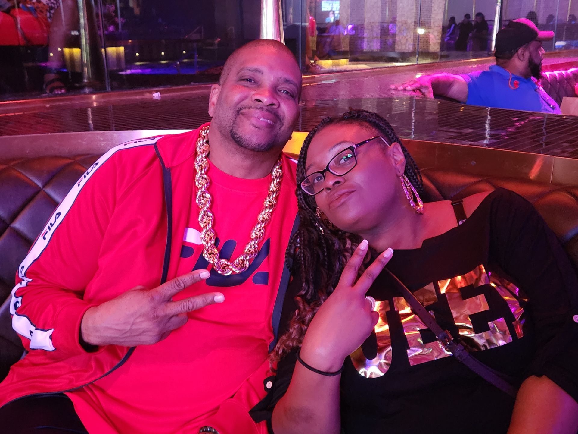 Danny and a woman are posing for a picture while sitting on a couch at an APRI 