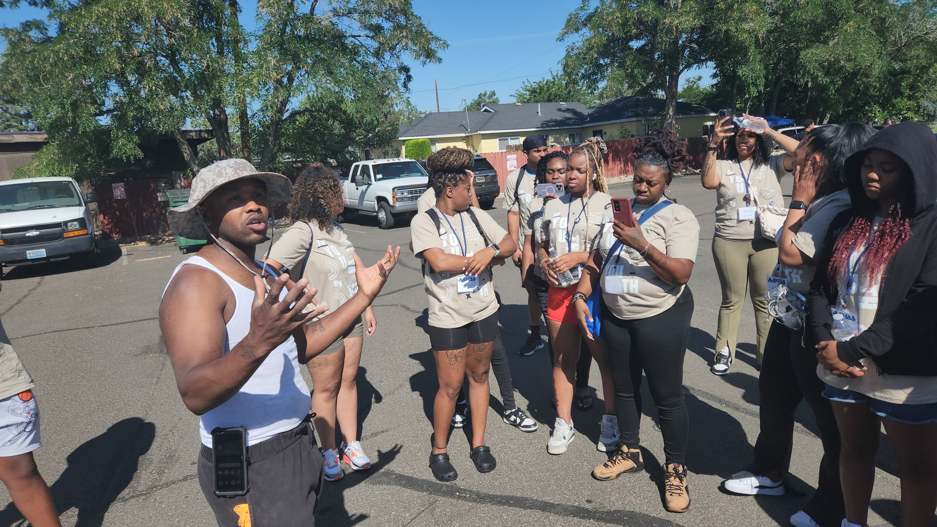 A group of APRI volunteers  standing in a parking lot making plans.