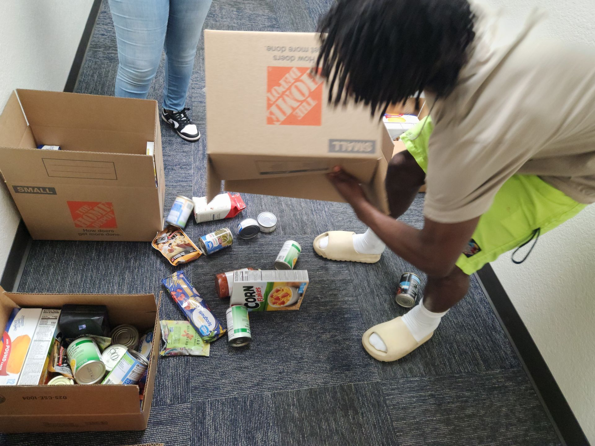 A young man is empties donations out of a home depot box  at an APRI eventcharity drive