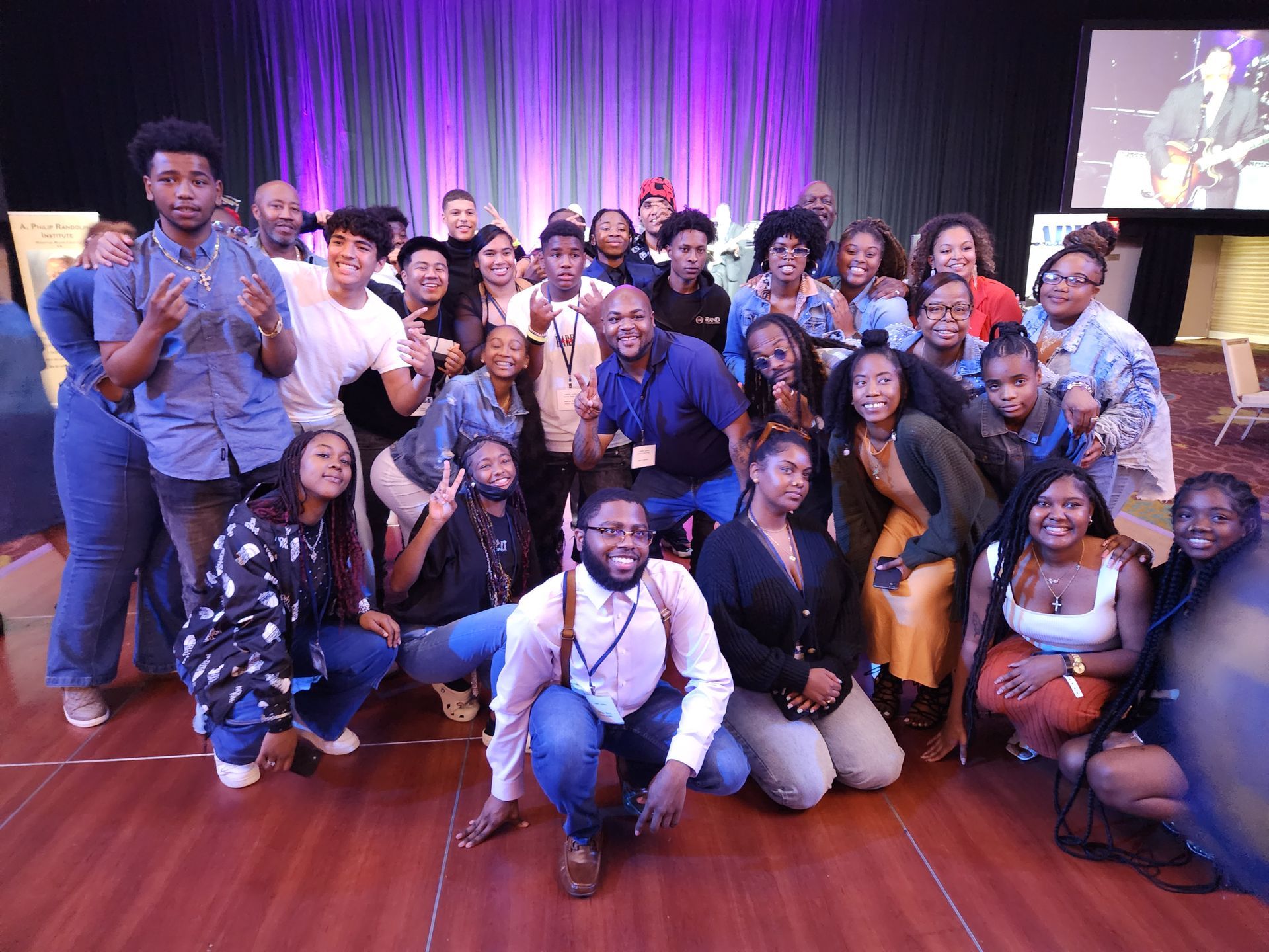 A large group of APRI Youth, posing for a picture in a room.