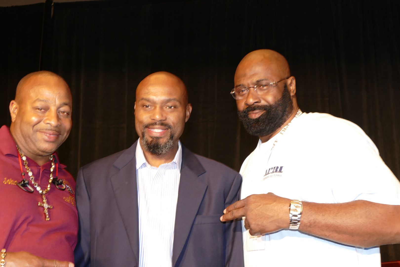 Three men posing for a picture  at an APRI event