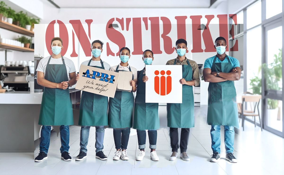 Six cafe workers in masks and aprons, standing with signs. 