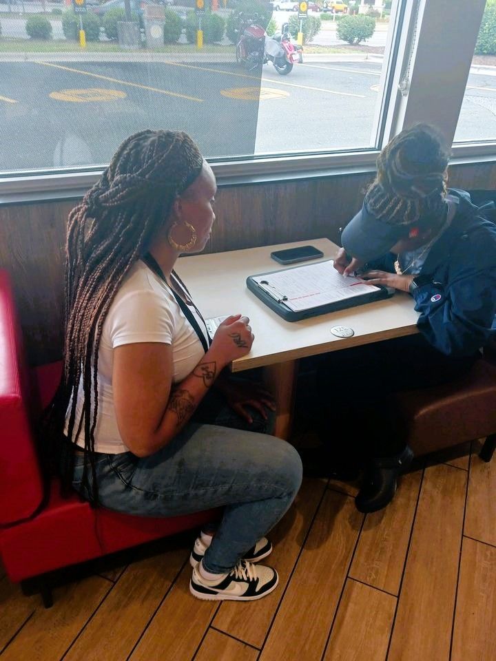 A beautiful voter registration volunteer with dreads in North Carolina helps a citizen register