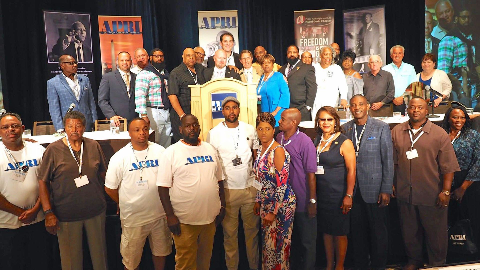 A group of people are posing for a picture and one of them is wearing a shirt that says samu