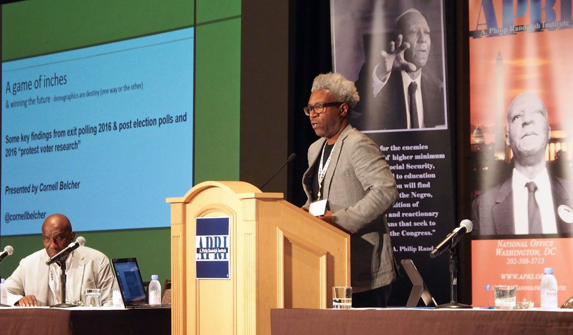 A man stands at a podium with a sign that says find