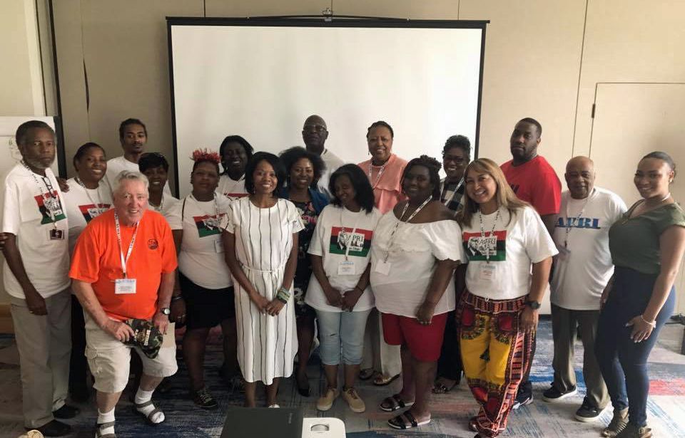 A group of people are posing for a picture in front of a projector screen.