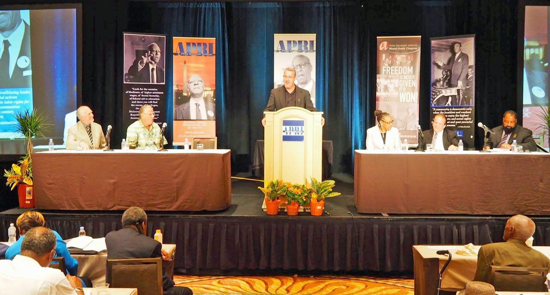 A man stands at a podium giving a speech at a conference