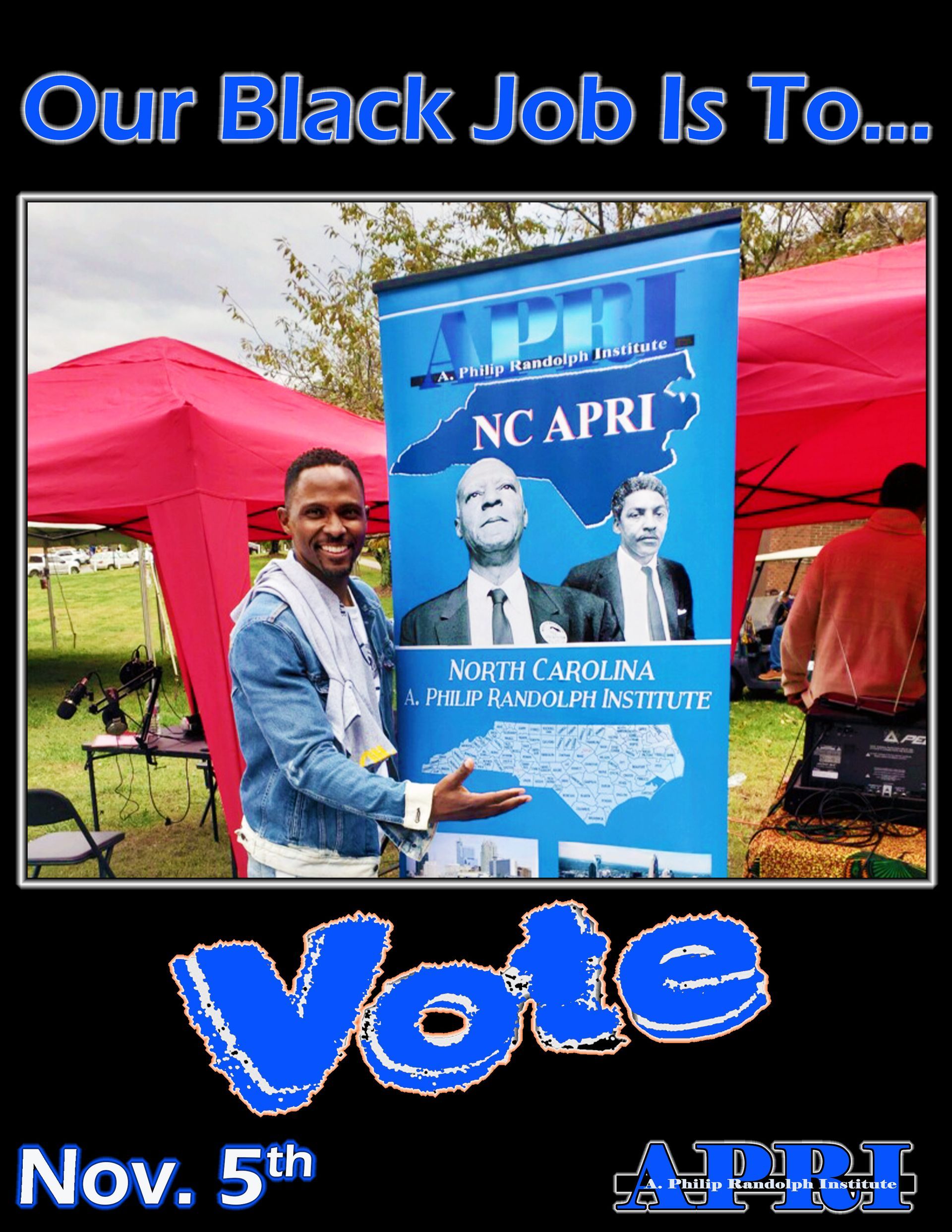 Voter registration volunteer stands proudly next to an APRI banner