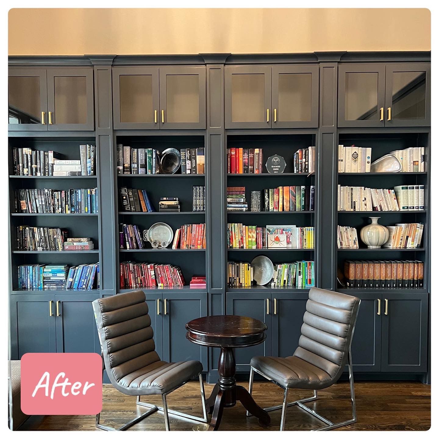 A living room with a table and chairs in front of a wall of bookshelves.