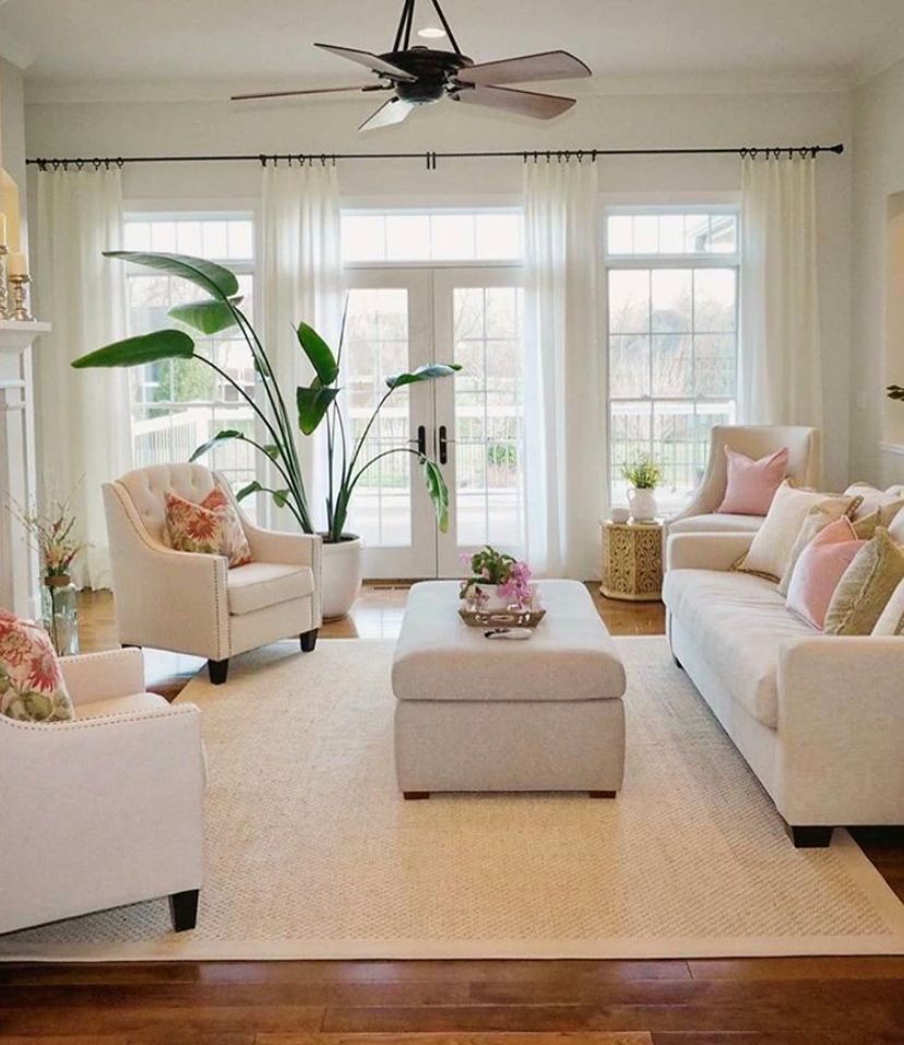 A living room with white furniture and a ceiling fan