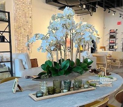 A table with a vase of flowers and candles on it.