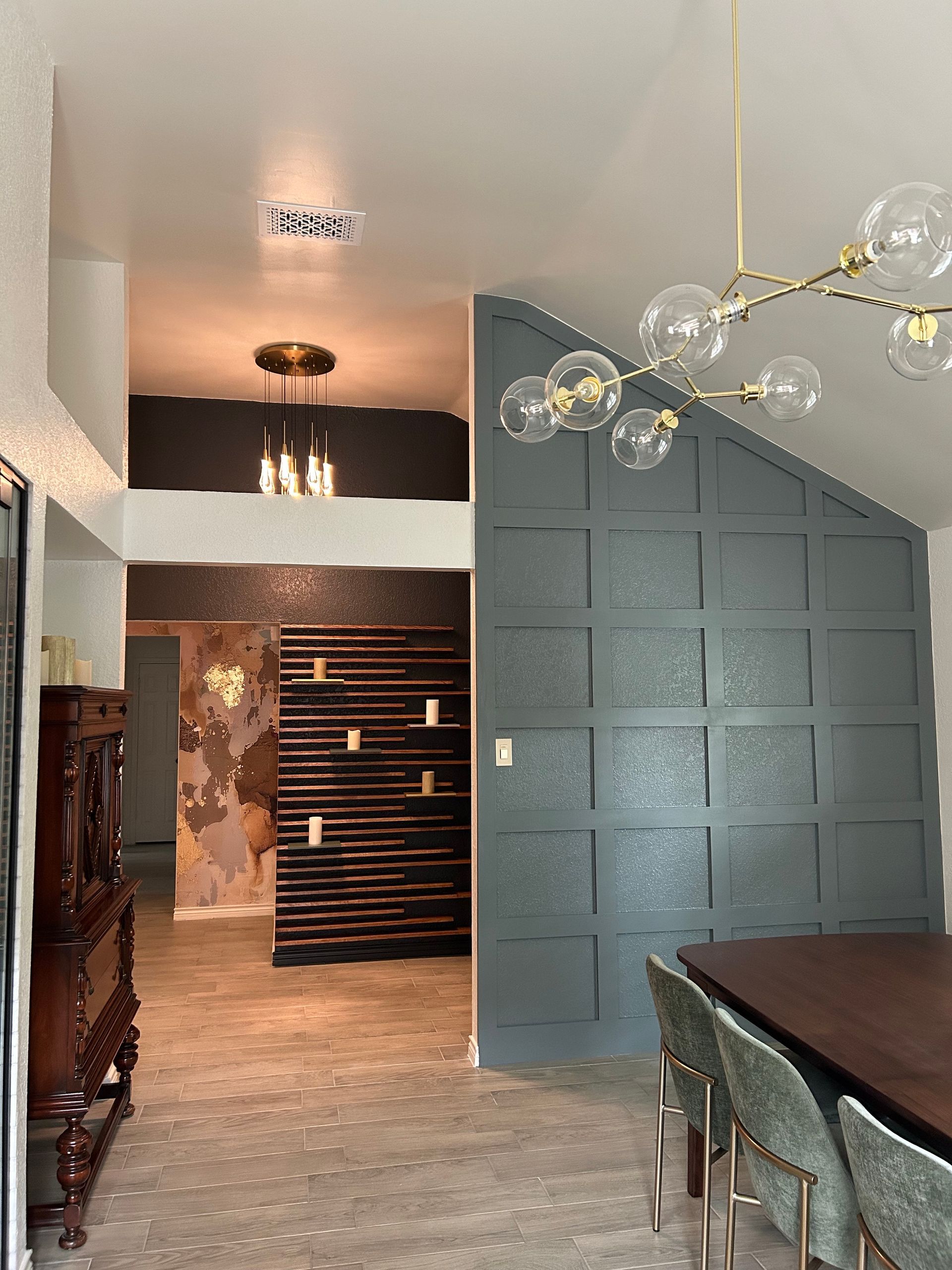 A dining room with a table and chairs and a chandelier hanging from the ceiling.