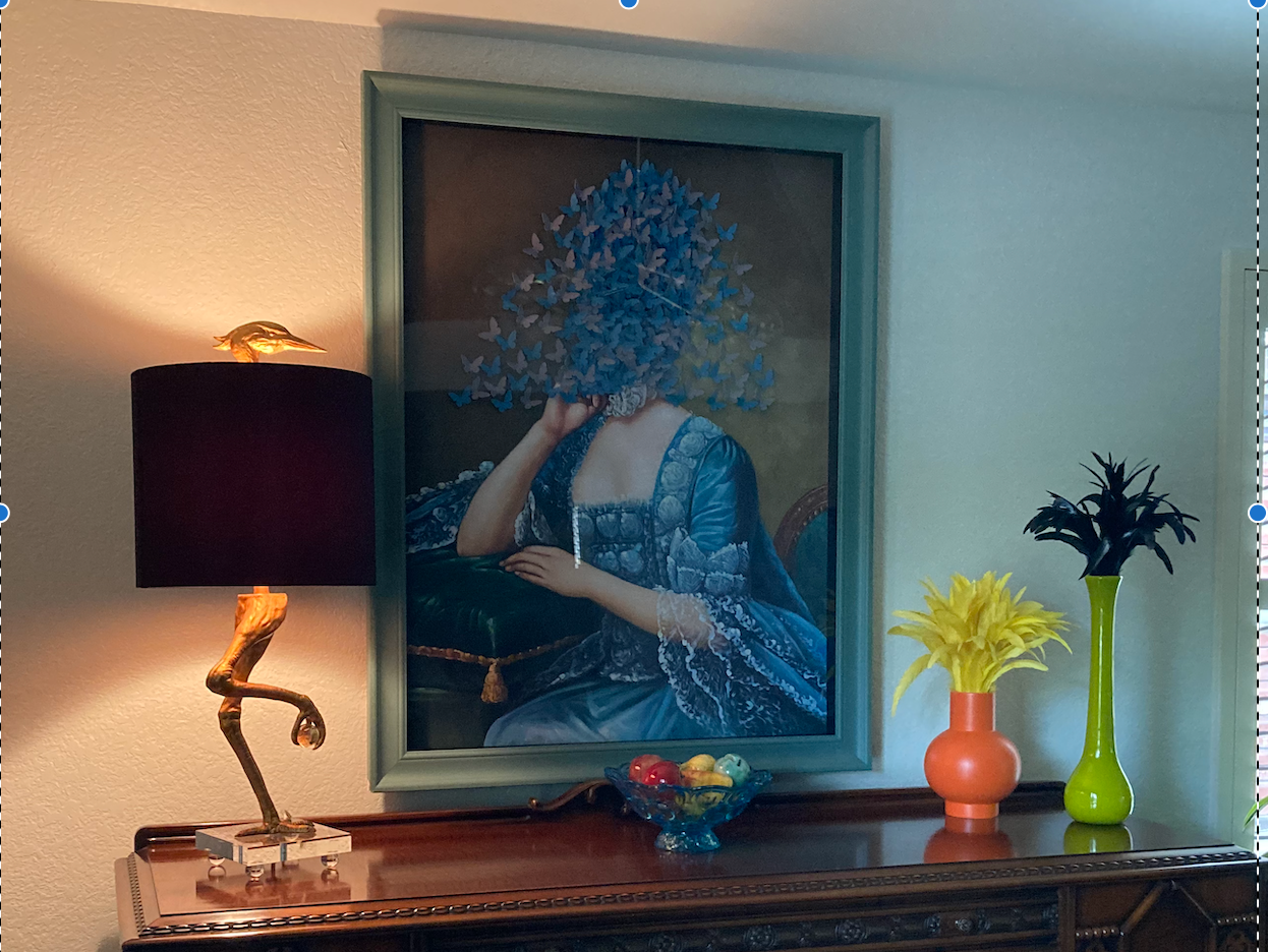 A framed painting of a woman with flowers on her face