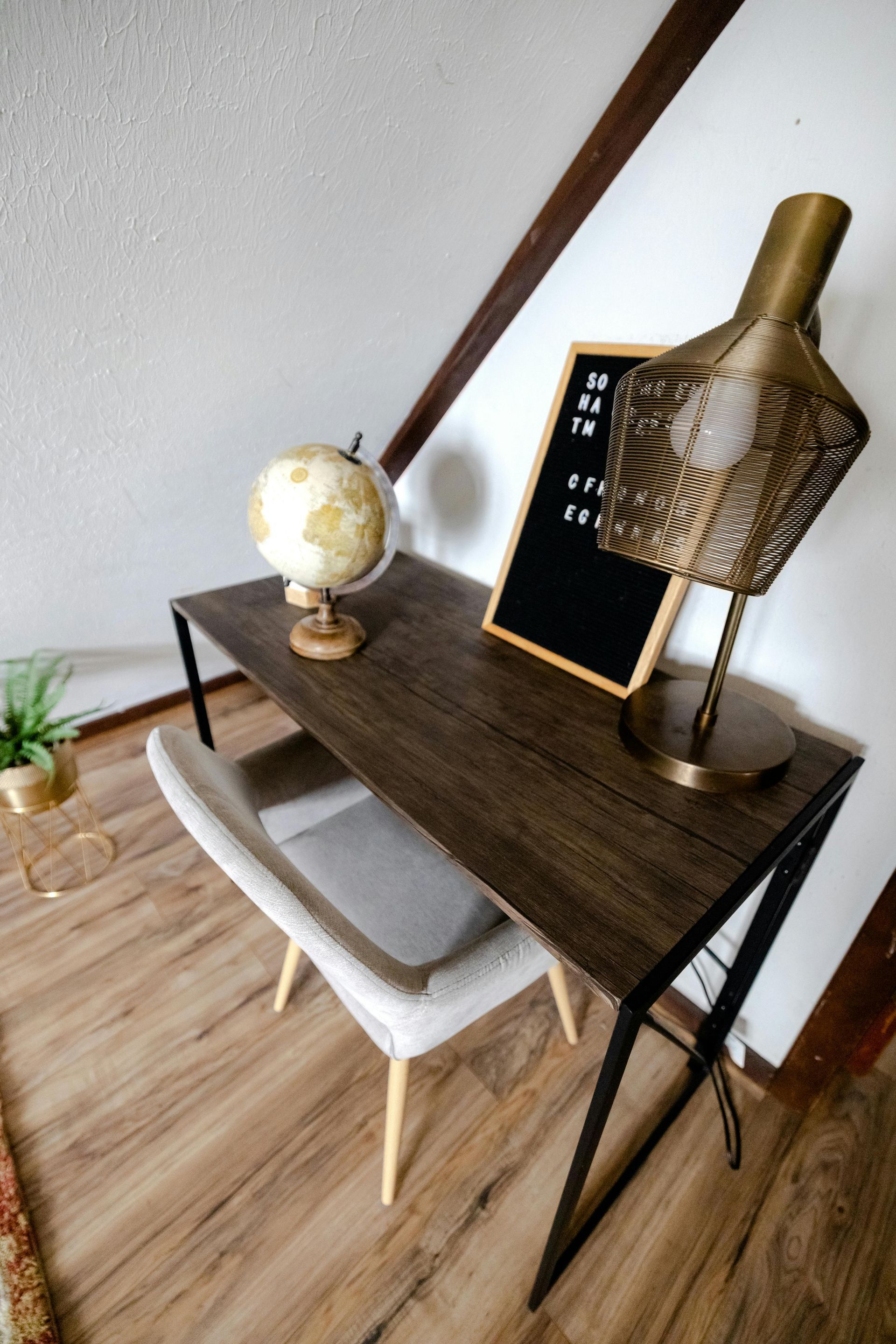 A desk with a globe and a lamp on it