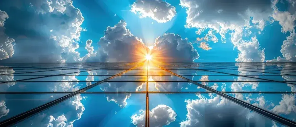 Sun shining through clouds above a reflective surface, resembling a pathway.