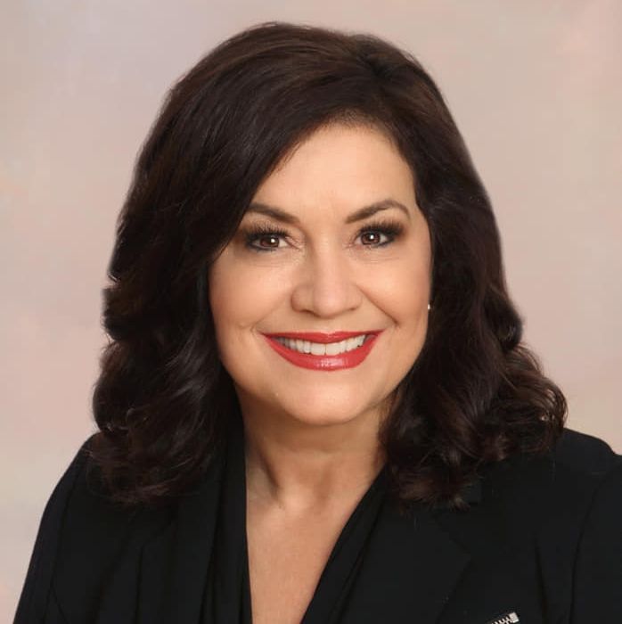 A man and a woman are sitting next to each other looking at a tablet.