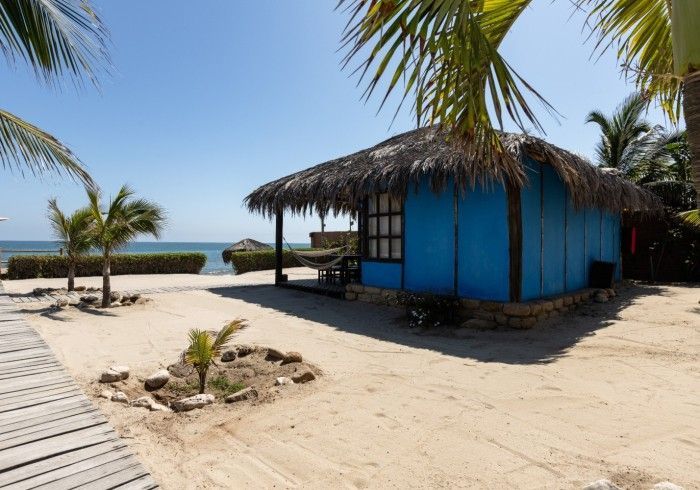 Dormitorio con puertas corredizas de vidrio, pisos de madera y muebles de bambú.