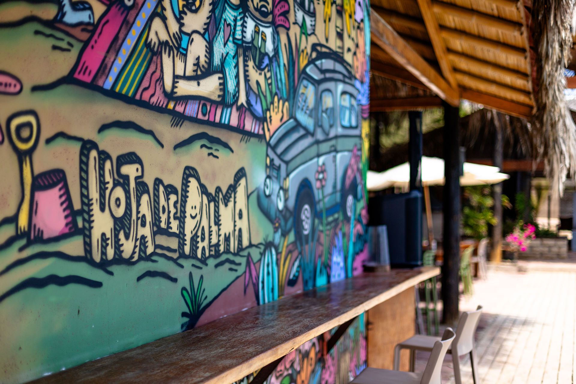 Bar con arte grafiti, mostrador de madera y un entorno exterior difuminado.