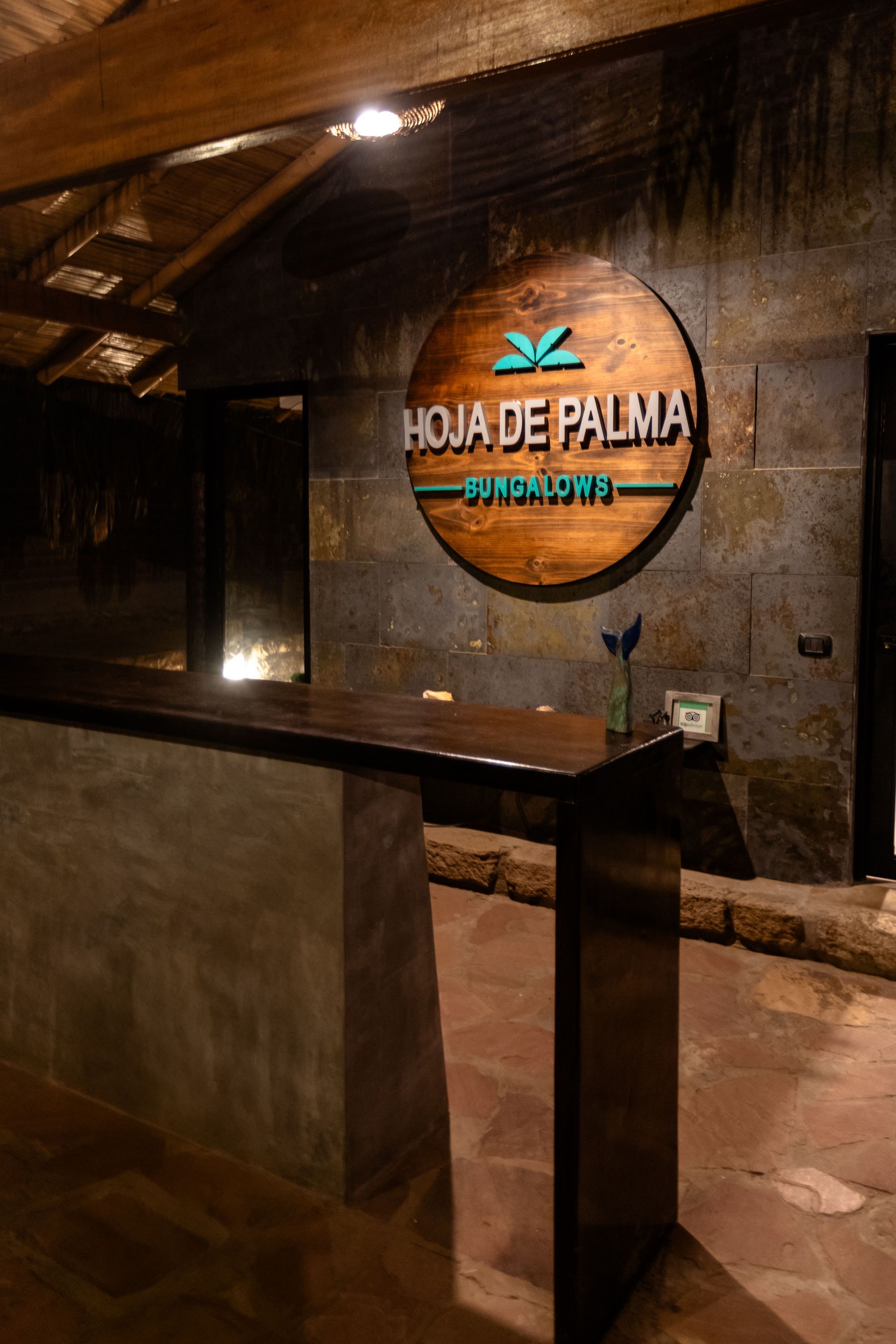 Área de recepción con un letrero de madera que dice