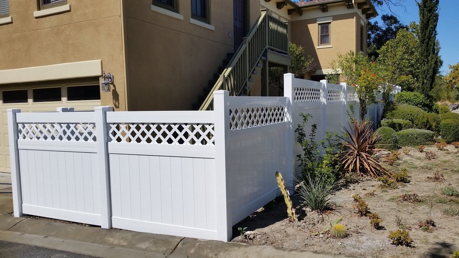 a white fence is sitting in front of a house .