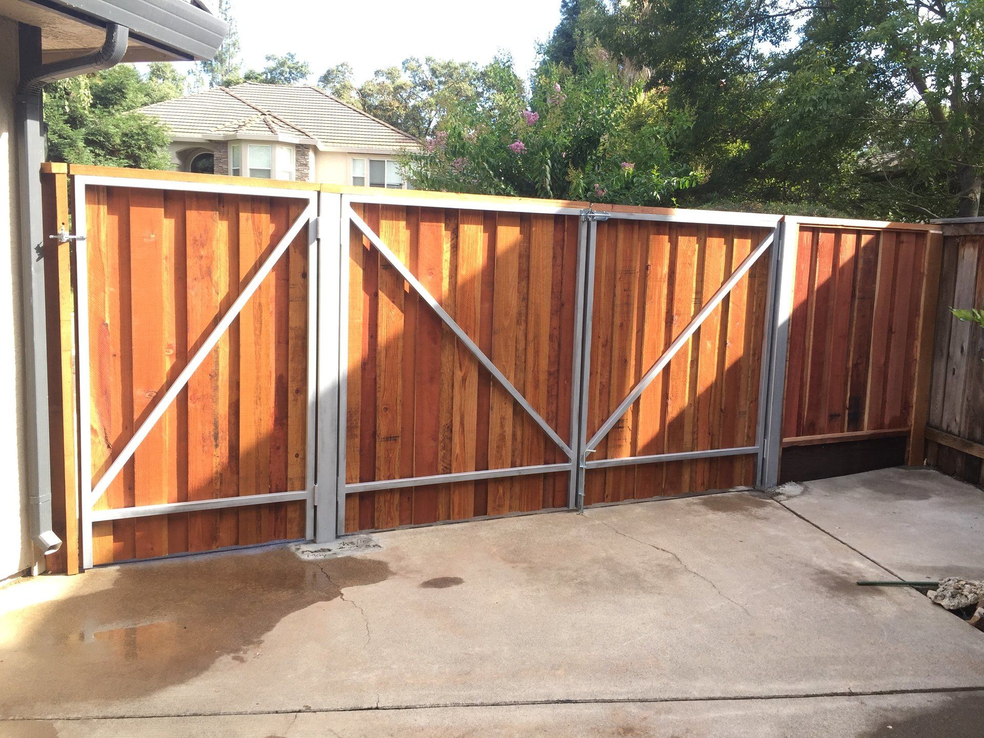 a wooden fence with a metal frame is in a driveway