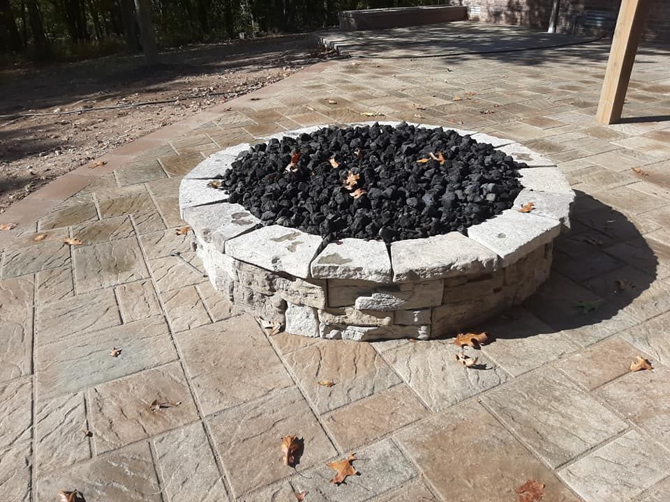 A fire pit is sitting on top of a tiled patio.