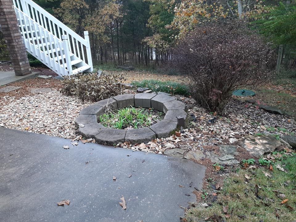 A fire pit is in the middle of a driveway next to a staircase.