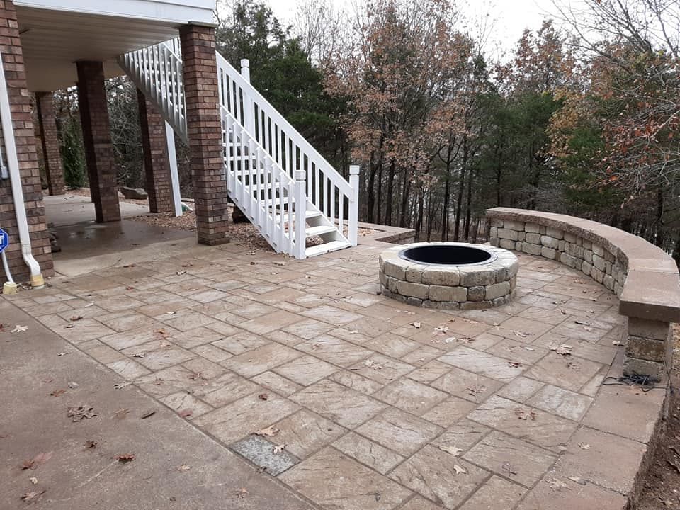 A fire pit is sitting on a patio next to a staircase.