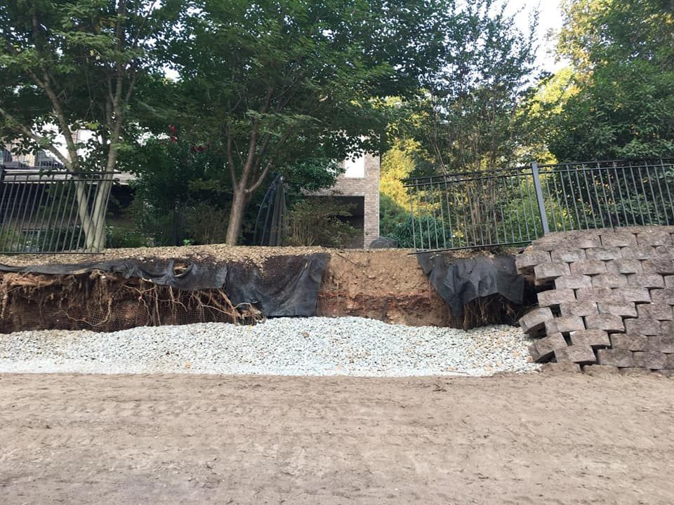 A concrete wall is being built in the backyard of a house.