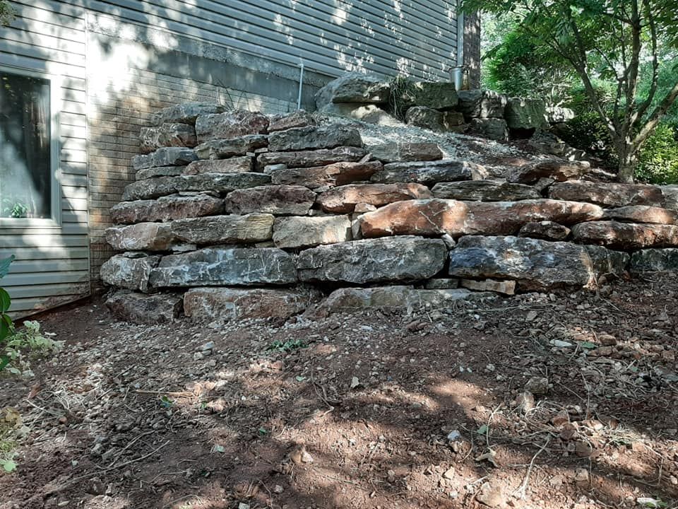 A large pile of rocks is sitting in front of a house.