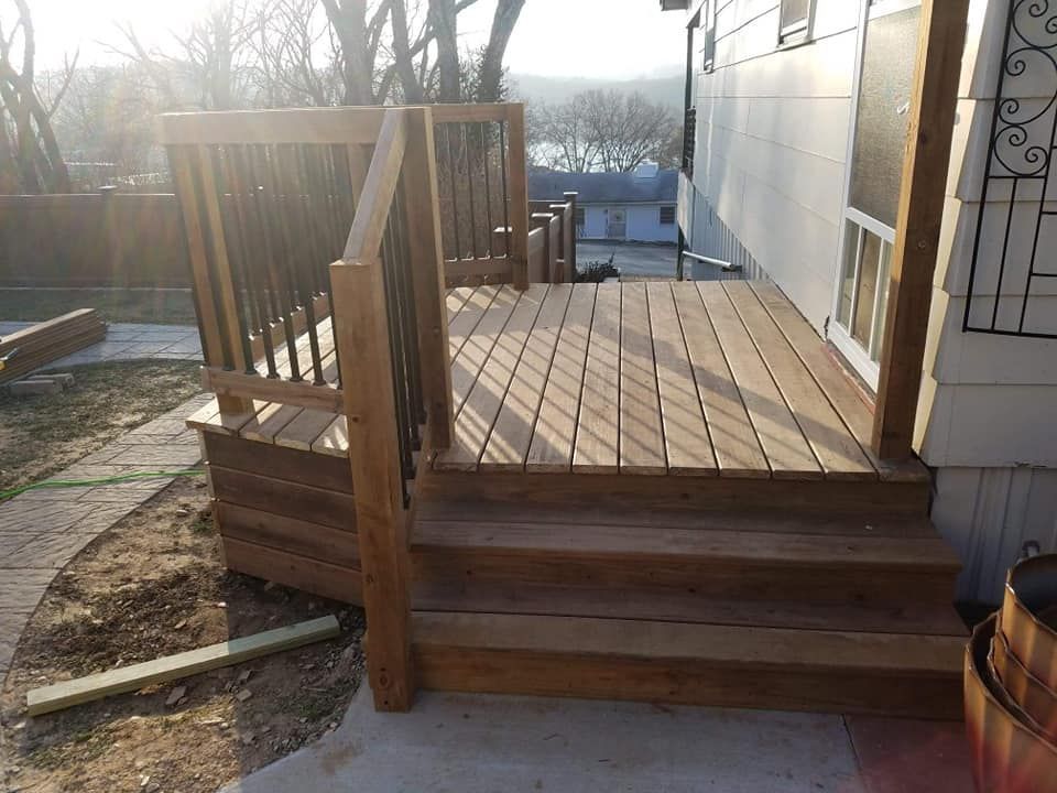 A wooden deck with stairs leading up to a house.